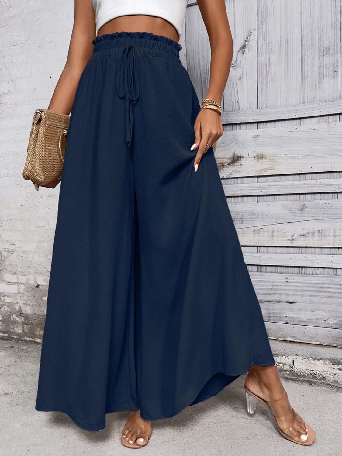Navy blue palazzo trousers with ruffled waist and drawstring detail.
