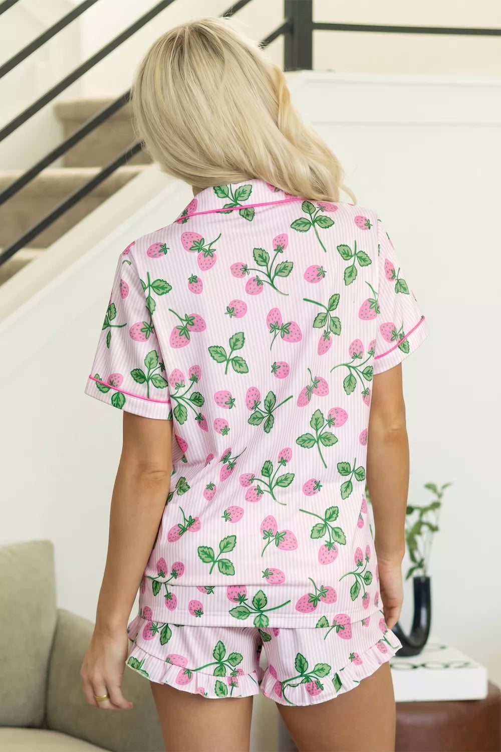 Pink striped pajama set with a whimsical strawberry print, featuring a button-up top and ruffled shorts.