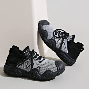 Black and gray knit athleisure sneakers with chunky soles and laces.