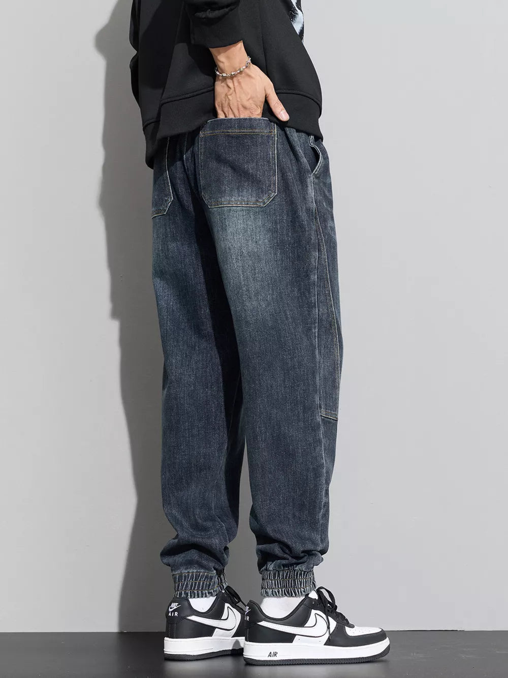 Medium wash denim joggers with drawstring waist and elastic cuffs.