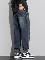 Medium wash denim joggers with drawstring waist and elastic cuffs.