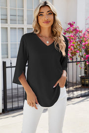 Black v-neck blouse with asymmetric split sleeves and a flowy fit.