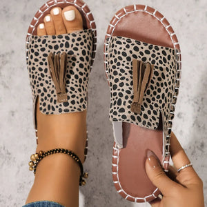 Spotted tassel slide sandals in mocha with brown tassels and contrast stitching.