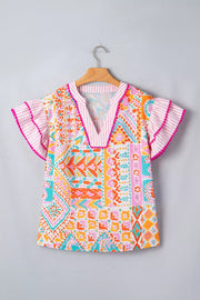 Vibrant patchwork ruffle detail blouse with pink striped trim and flutter sleeves.