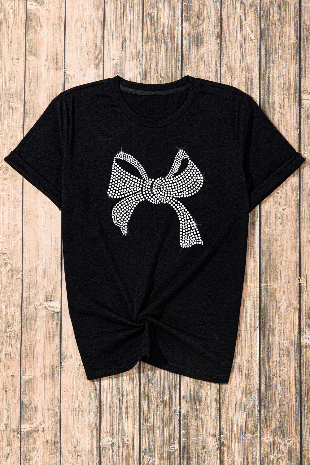 Black t-shirt with rhinestone bow graphic and knotted hem.
