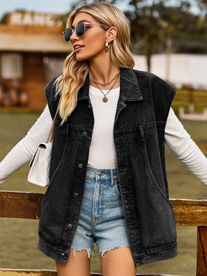 Black oversized denim sleeveless jacket with button front and chest pockets.