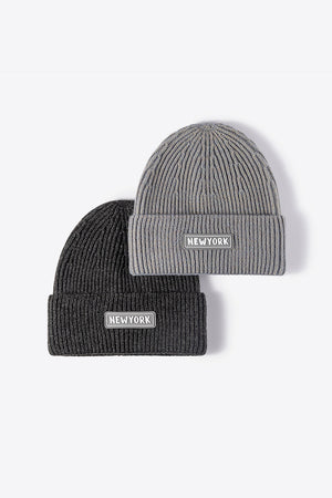 Ribbed acrylic beanies in gray and black, each with a New York patch detail.