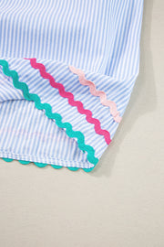 Light blue striped blouse with scalloped trim in pink and green.