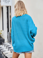 Oversized slouch knit sweater in blue with V-neck and relaxed fit.