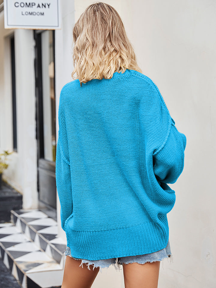 Oversized slouch knit sweater in blue with V-neck and relaxed fit.