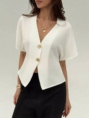White asymmetrical V-neck buttoned shirt with gold buttons and short sleeves.