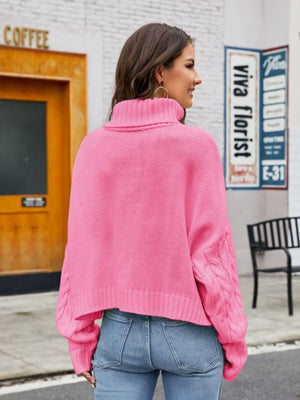 Pink cable-knit acrylic sweater with a high neck and cuffed sleeves.