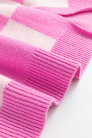Checkered polo neckline knit sweater in fuchsia pink and white with ribbed cuffs.