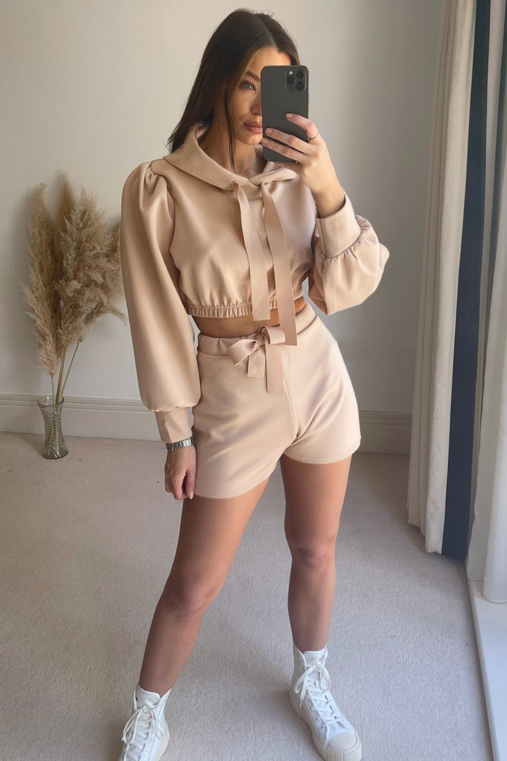 Blush pink cropped hoodie with puff sleeves and tie detail, paired with matching shorts.