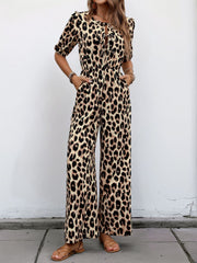 Leopard print jumpsuit with puff sleeves and tie-neck detail.