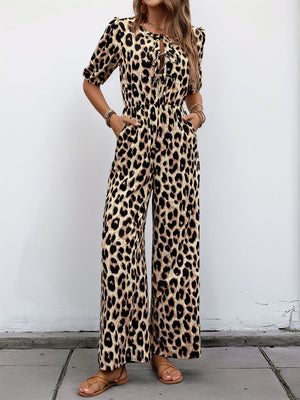 Leopard print jumpsuit with puff sleeves and tie-neck detail.