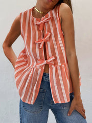 Orange and white striped peplum top with bow tie closures and a ruffled hem.