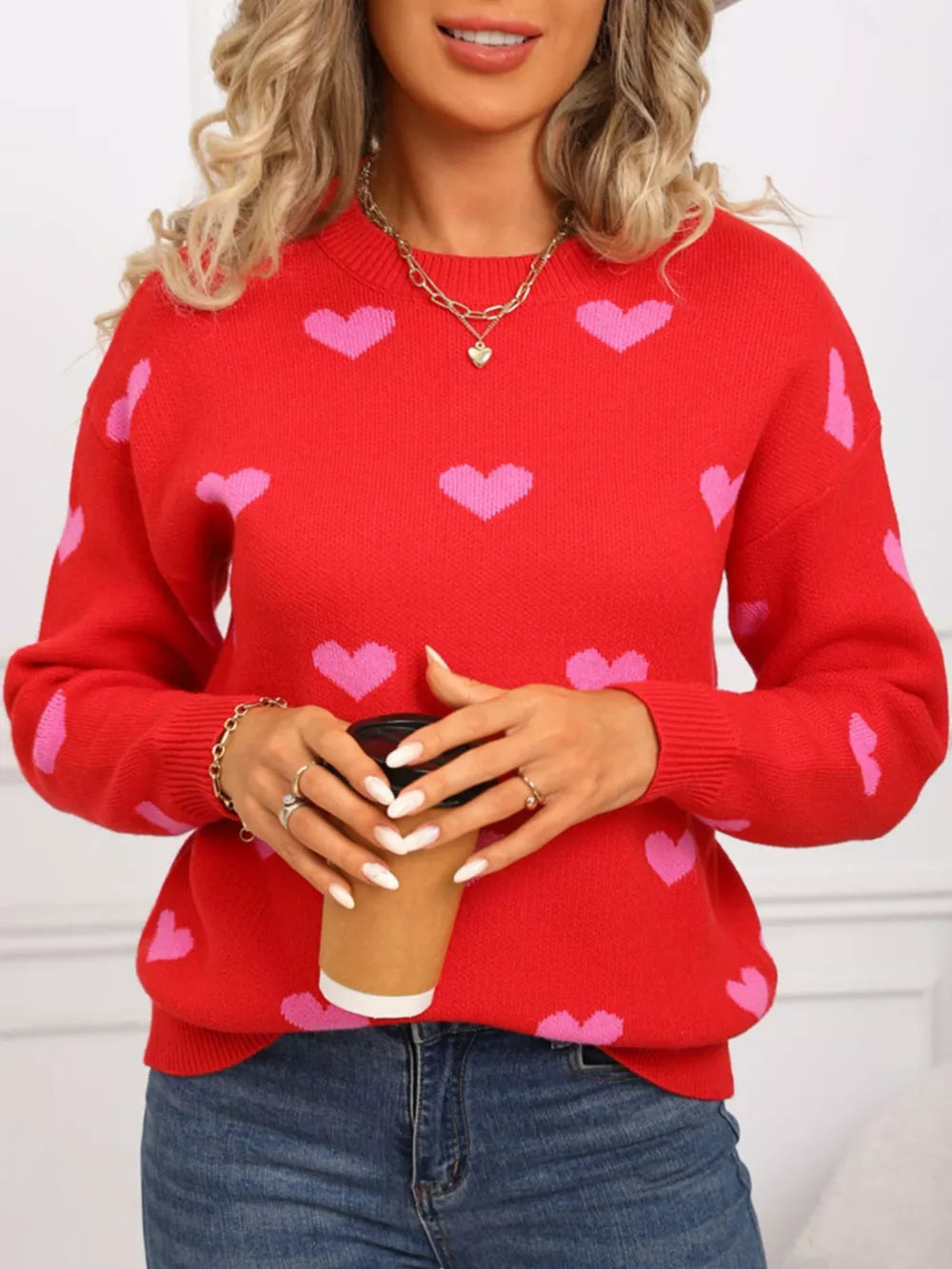 Red acrylic sweater with pink heart print, crew neck, long sleeves.