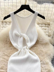 White ribbed knit midi dress with a knot-back detail and cutout.