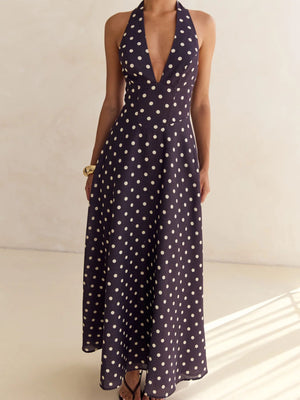 Navy polka dot halter neck maxi dress with a deep V-neck and A-line skirt.