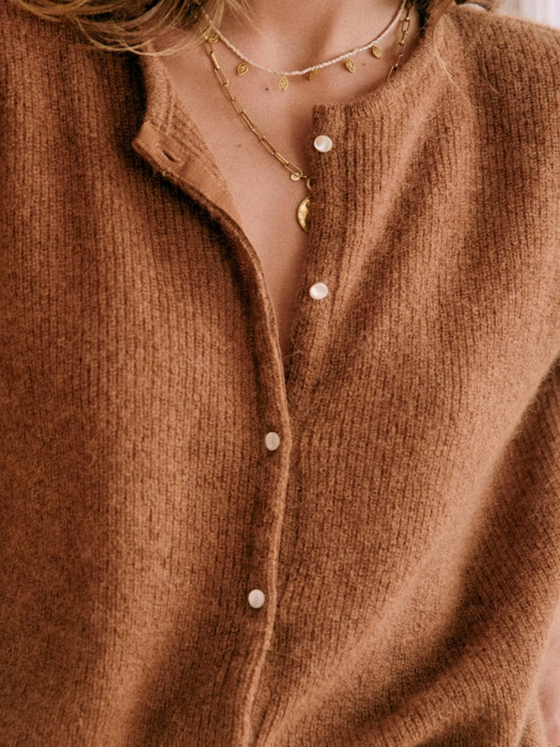 Caramel cashmere button cardigan with a plunging neckline and pearl buttons.
