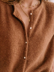 Caramel cashmere button cardigan with a plunging neckline and pearl buttons.