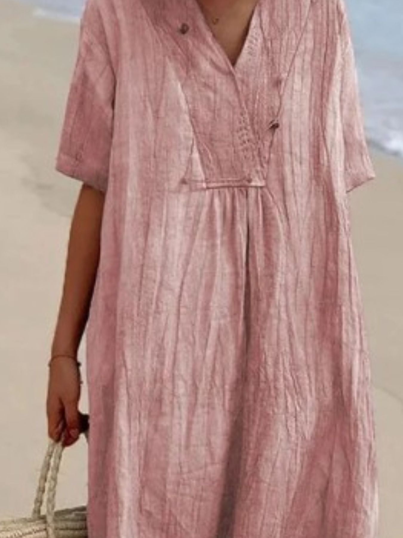 Pink V-neck casual midi dress with short sleeves and textured fabric.