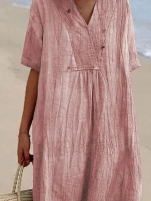 Pink V-neck casual midi dress with short sleeves and textured fabric.