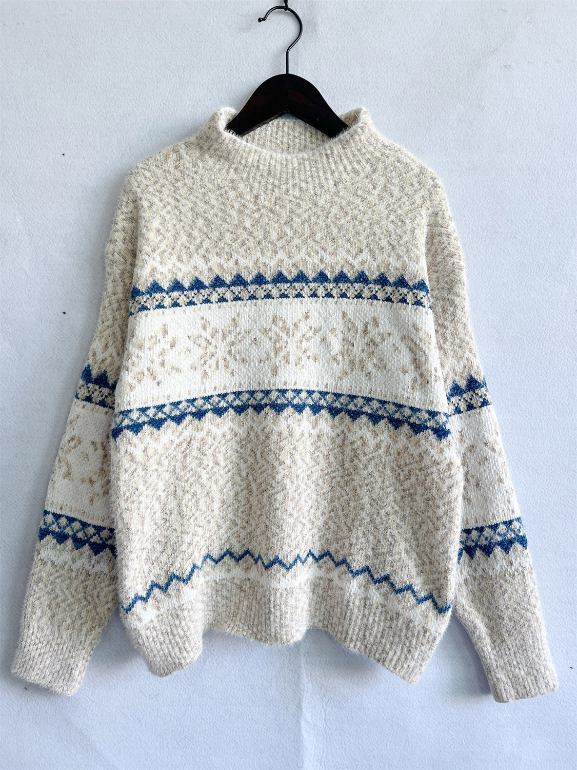 Geometric knit mockneck pullover in eggshell with blue and white fair isle pattern.