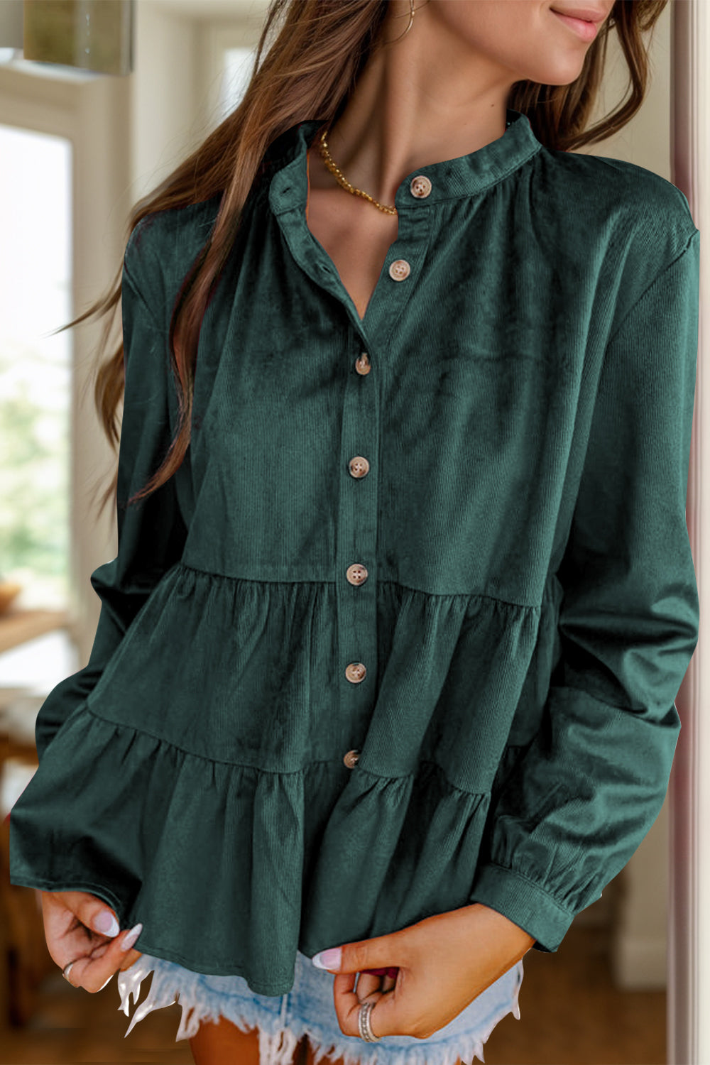 Dark green corduroy tiered button-up blouse with a stand collar and long sleeves.