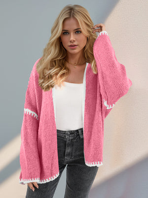Pink oversized knit cardigan with contrast white stitching detail and wide sleeves.