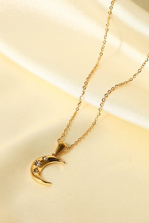 Gold crescent moon pendant necklace with star-shaped zirconia accents on a delicate chain.