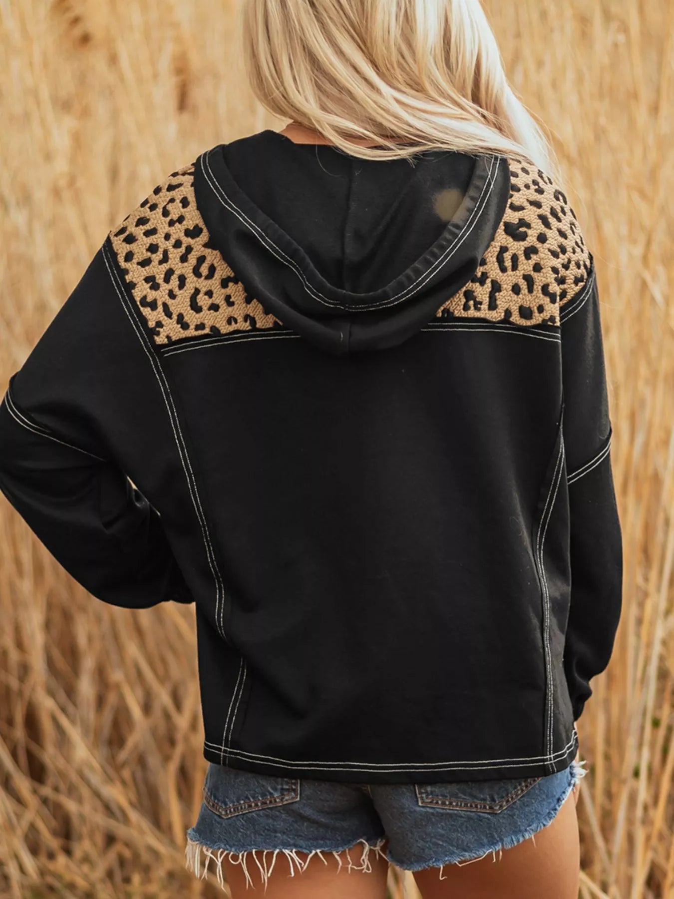 Black zip hoodie with leopard print shoulder detail and contrast stitching.