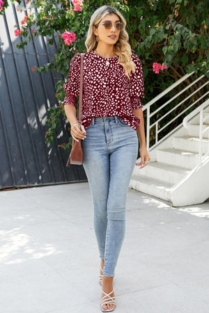 Burgundy textured spot print blouse with shirred sleeves and round neckline.