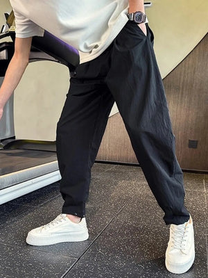 Black cargo pants with adjustable cuffs and a relaxed fit, styled with a white t-shirt and sneakers.
