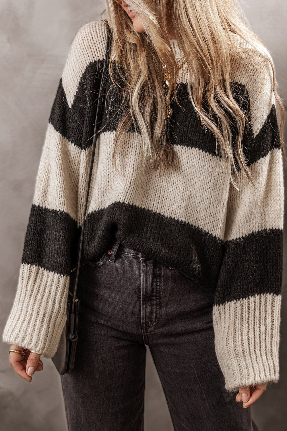 Relaxed knit sweater with bold black and cream stripes, acrylic blend, crew neck, long sleeves.