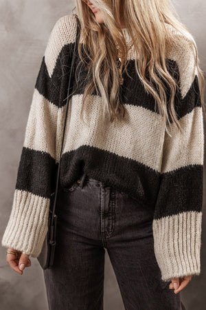 Relaxed knit sweater with bold black and cream stripes, acrylic blend, crew neck, long sleeves.