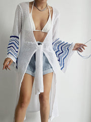 White knit duster cardigan with blue chevron sleeves and tie front.