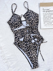 Leopard print one-piece swimsuit with cutout details and lace-up front.