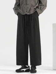 Men's black wide-leg drawstring casual trousers with a relaxed fit.