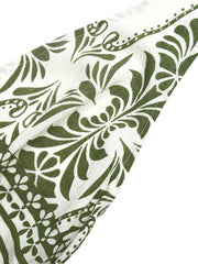 White halter neck jumpsuit with green botanical print and floral border detail.