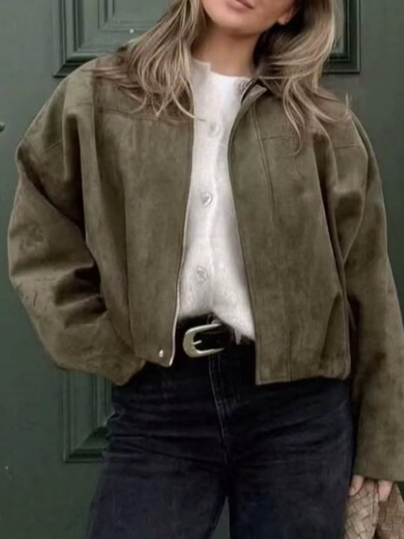 Oversized military green zip-up jacket with a collar, styled with a white shirt and black jeans.