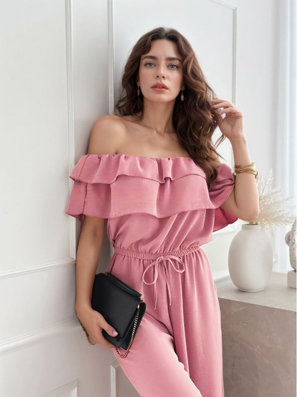 Dusty pink off-shoulder ruffle palazzo jumpsuit with drawstring waist and wide legs.