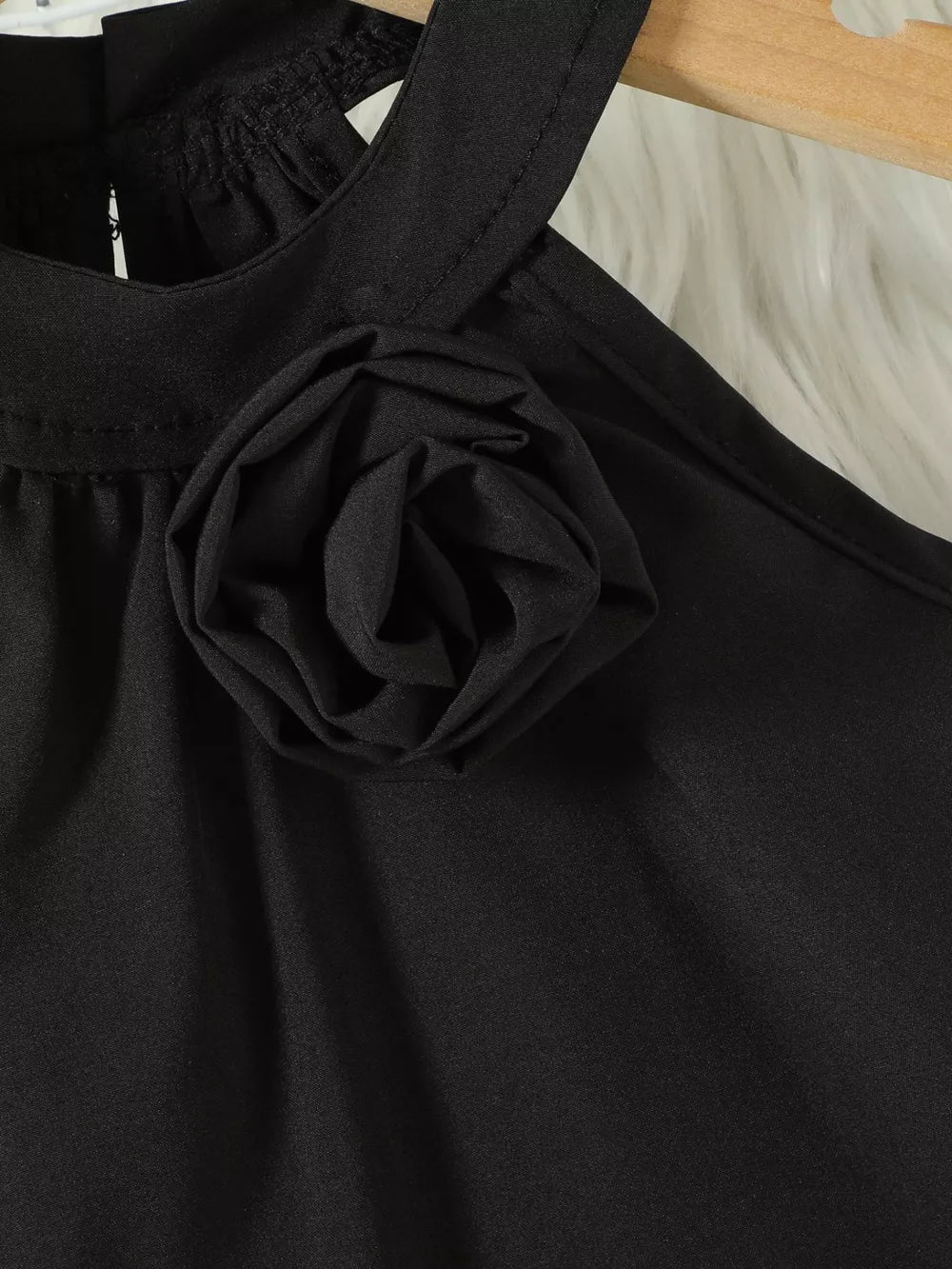 Black toddler top with halter neck and fabric rose applique detail.