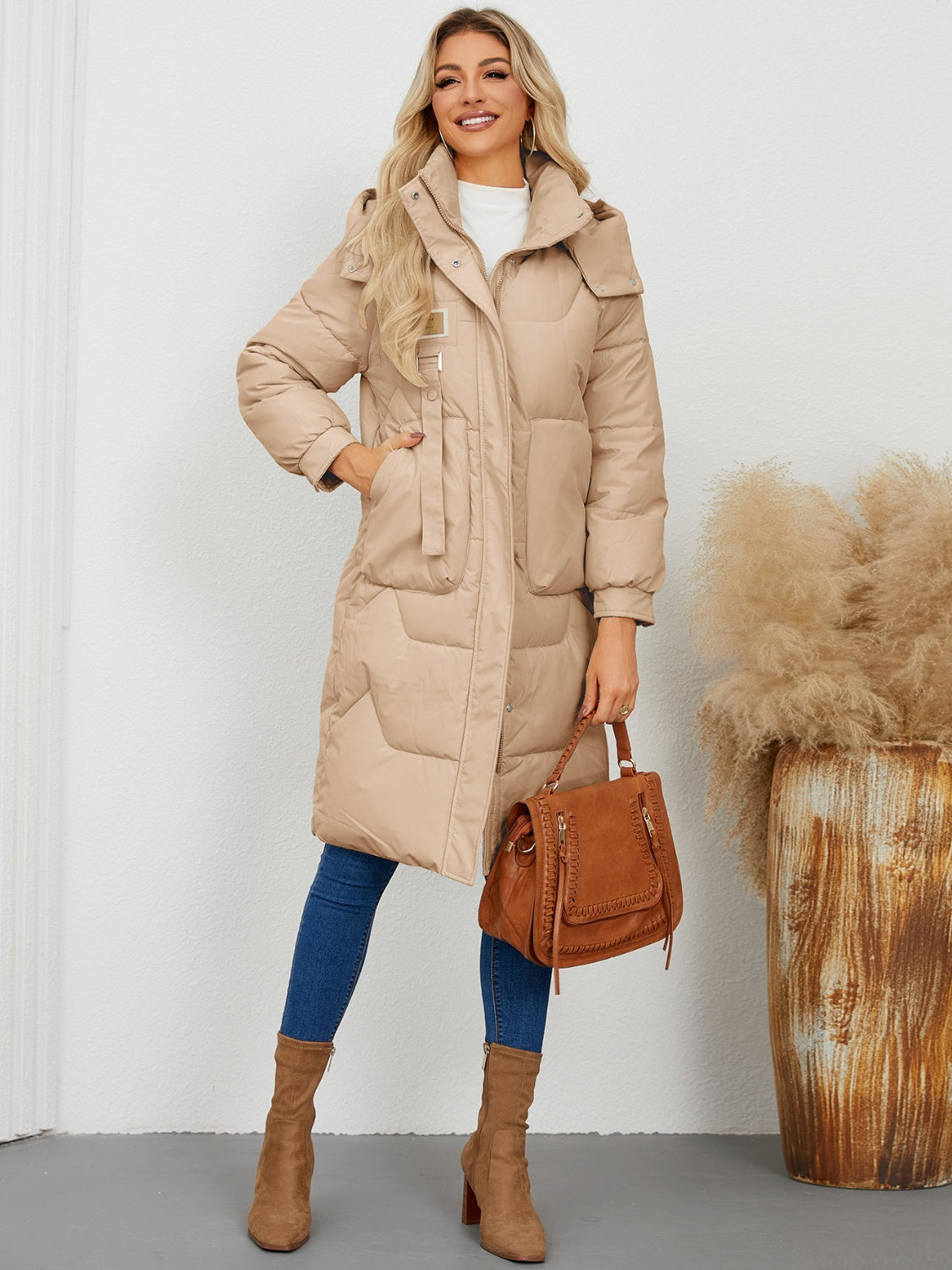 Camel quilted puffer parka with hood and buckle detail, full length.
