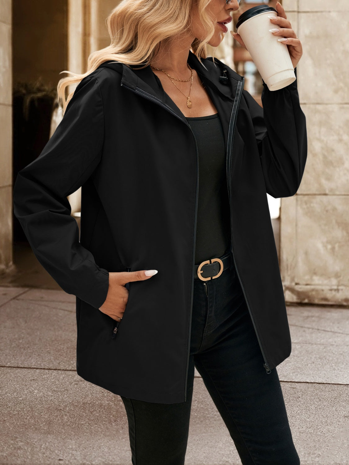 Black zip-through hooded jacket with pockets, styled casually.