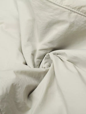 Men's wide-leg sweatpants in light gray with a crinkled texture.