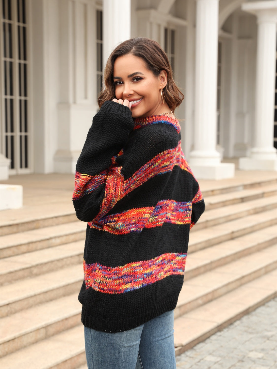Black acrylic slouchy knit sweater with rainbow stripes and crew neck.
