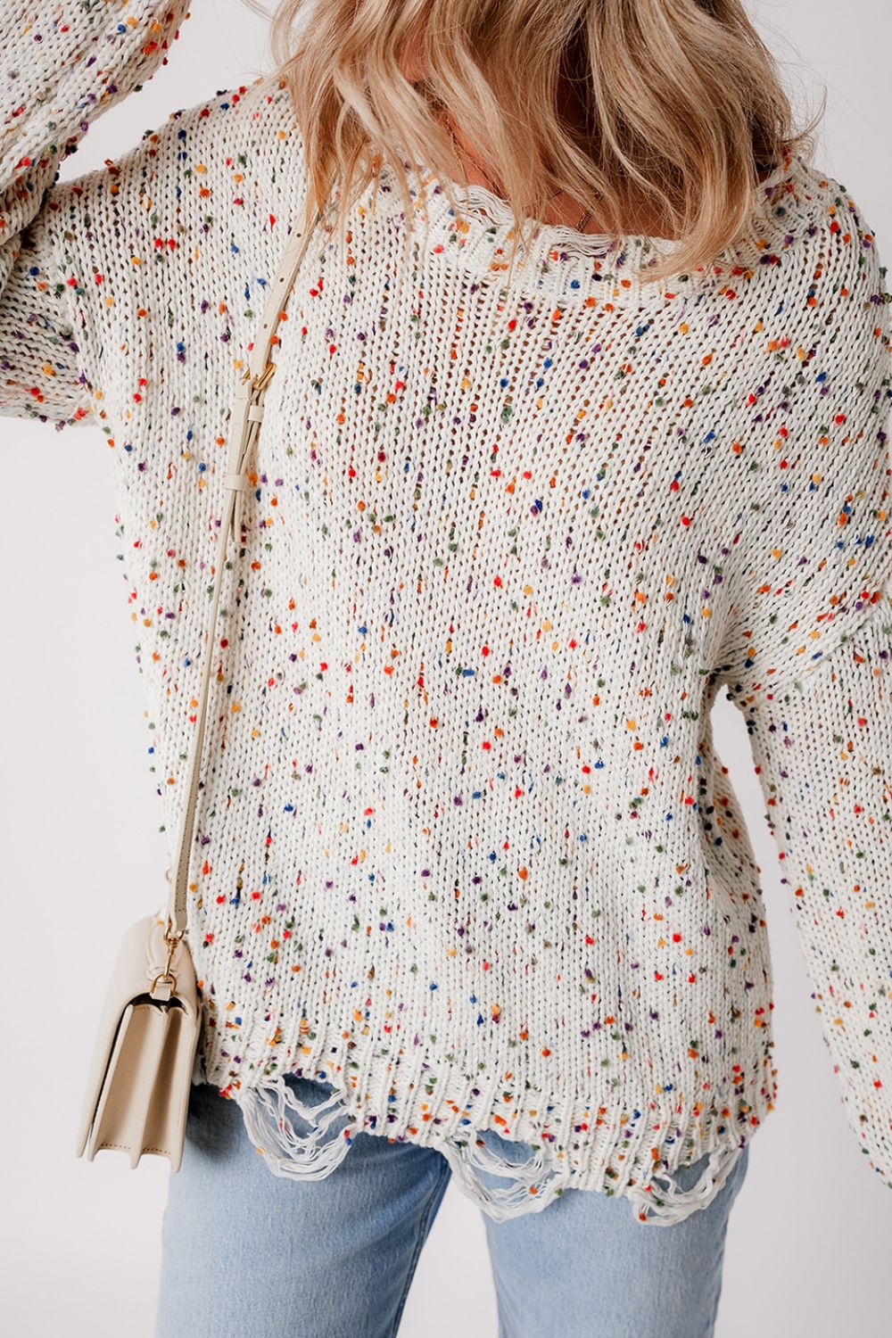 Confetti knit sweater in white with colorful flecks and distressed hem.