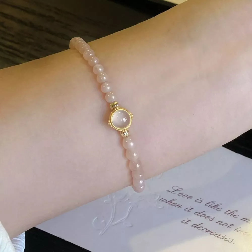 Gold-plated bracelet with blush pink beads and a moonstone centerpiece.